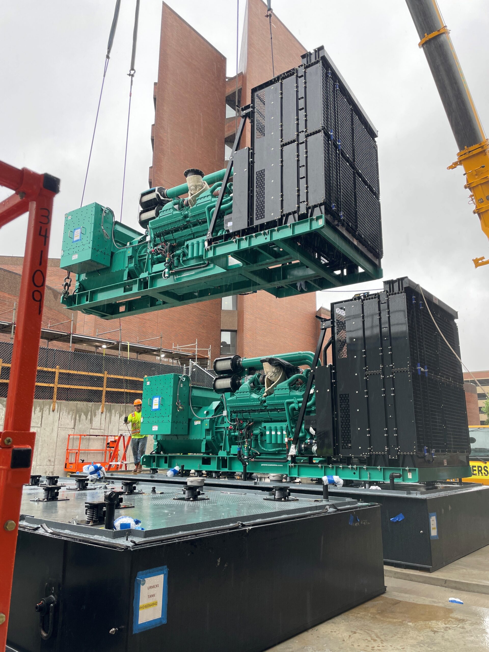 generators being lifted onto roof of building with a crane