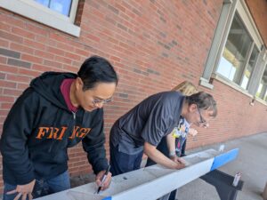2 people working on a construction beam