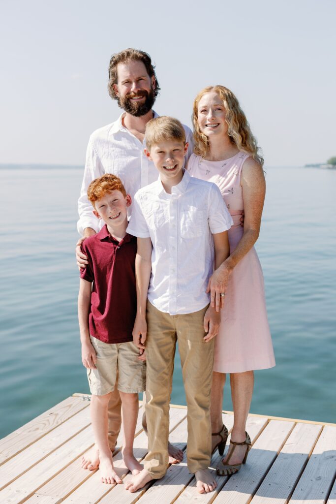 Andrew Lytwynec with his wife Jill, and 2 children posing on a dock with a body of water behind them