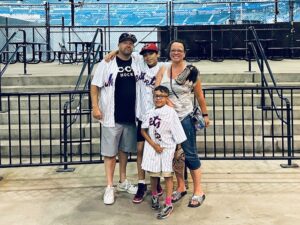 Tom Conroy in a family pic, dress in baseball regalia at a stadium