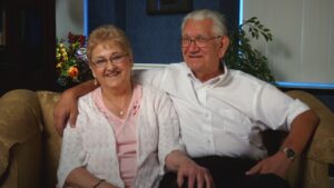 Danny Pszczolkowski and Esther FitzRandolph sitting on a couch together