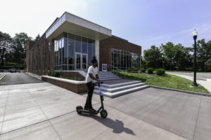 Person on scooter in front of Sloan Center