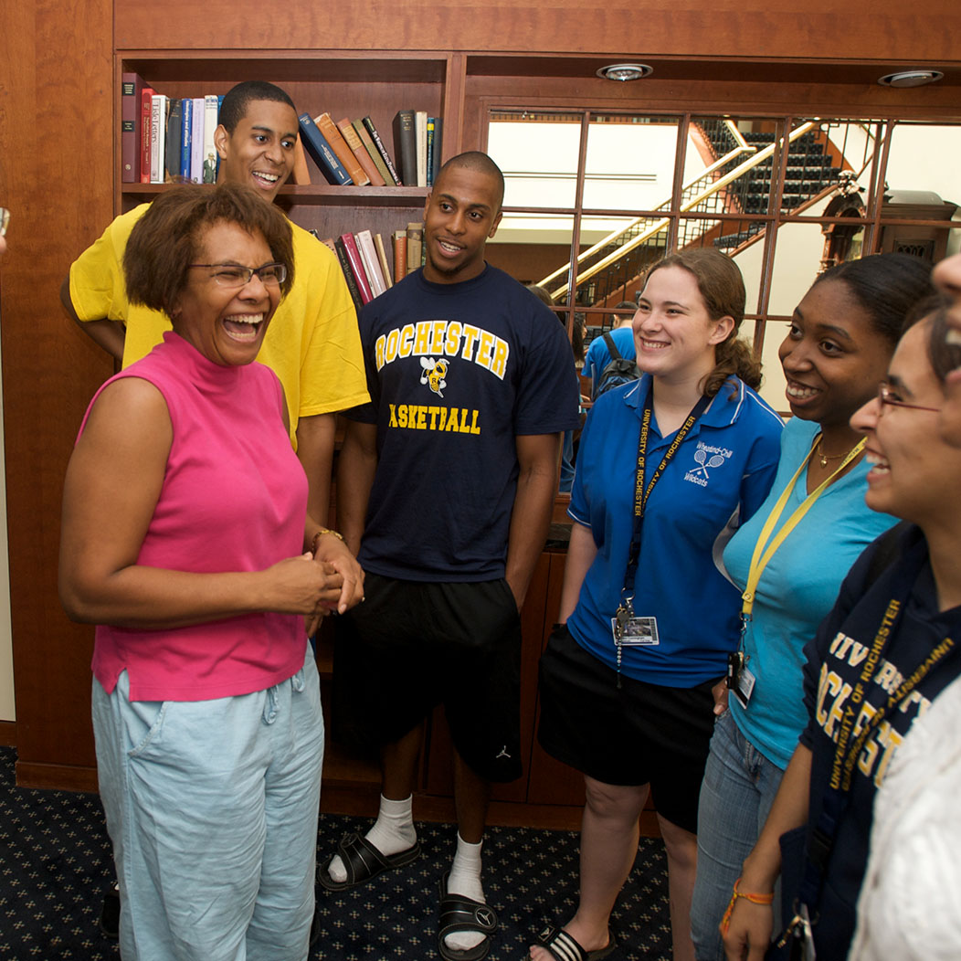 Lisa Norwood posing with a group of students and a huge smile on her face