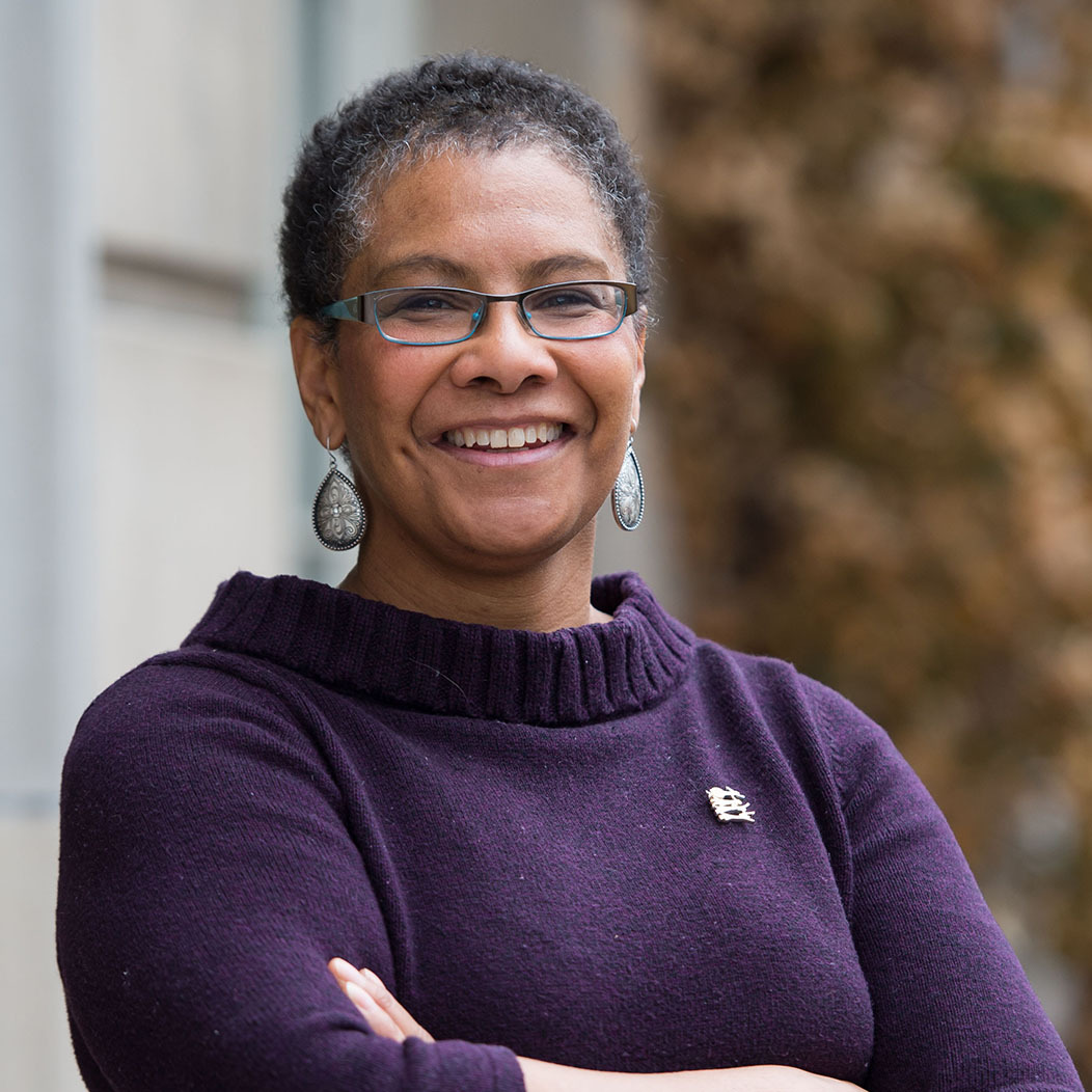 Lisa Norwood smiling with her arms crossed wearing a purple sweater
