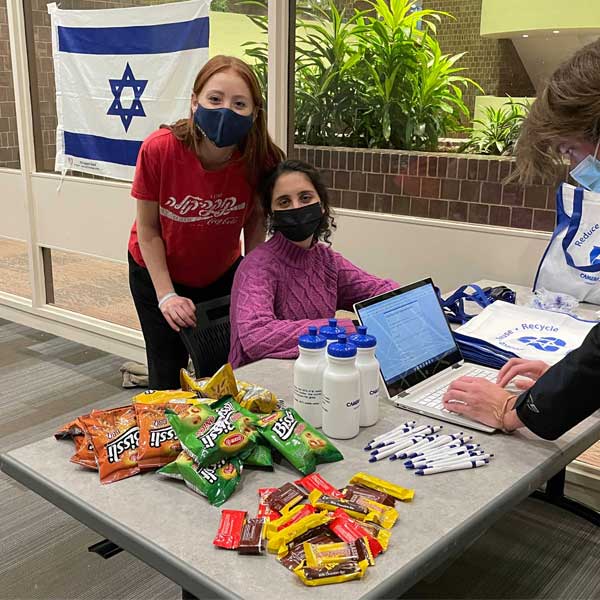 two students at a table with candy with jewish flag in background
