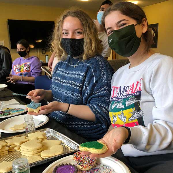 two students decorating cookies