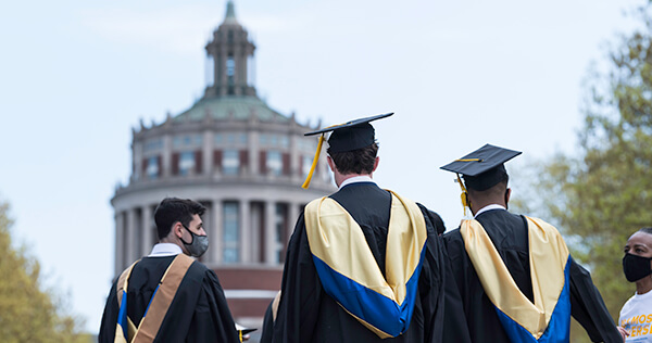 Three graduates head onto the quad before the ceremony forSimon School of Business commencement at Eastman Quadrangle