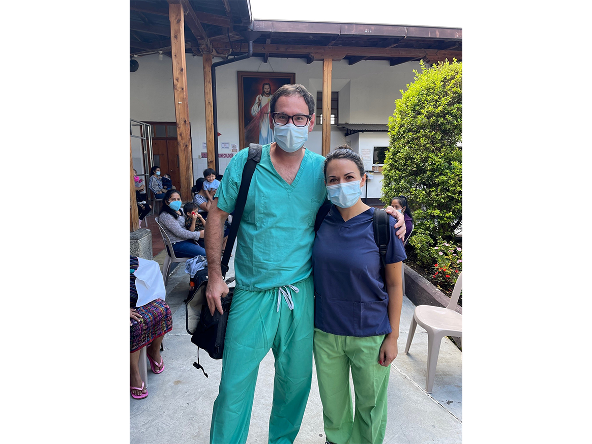 2 people posing with surgical masks and scrubs on