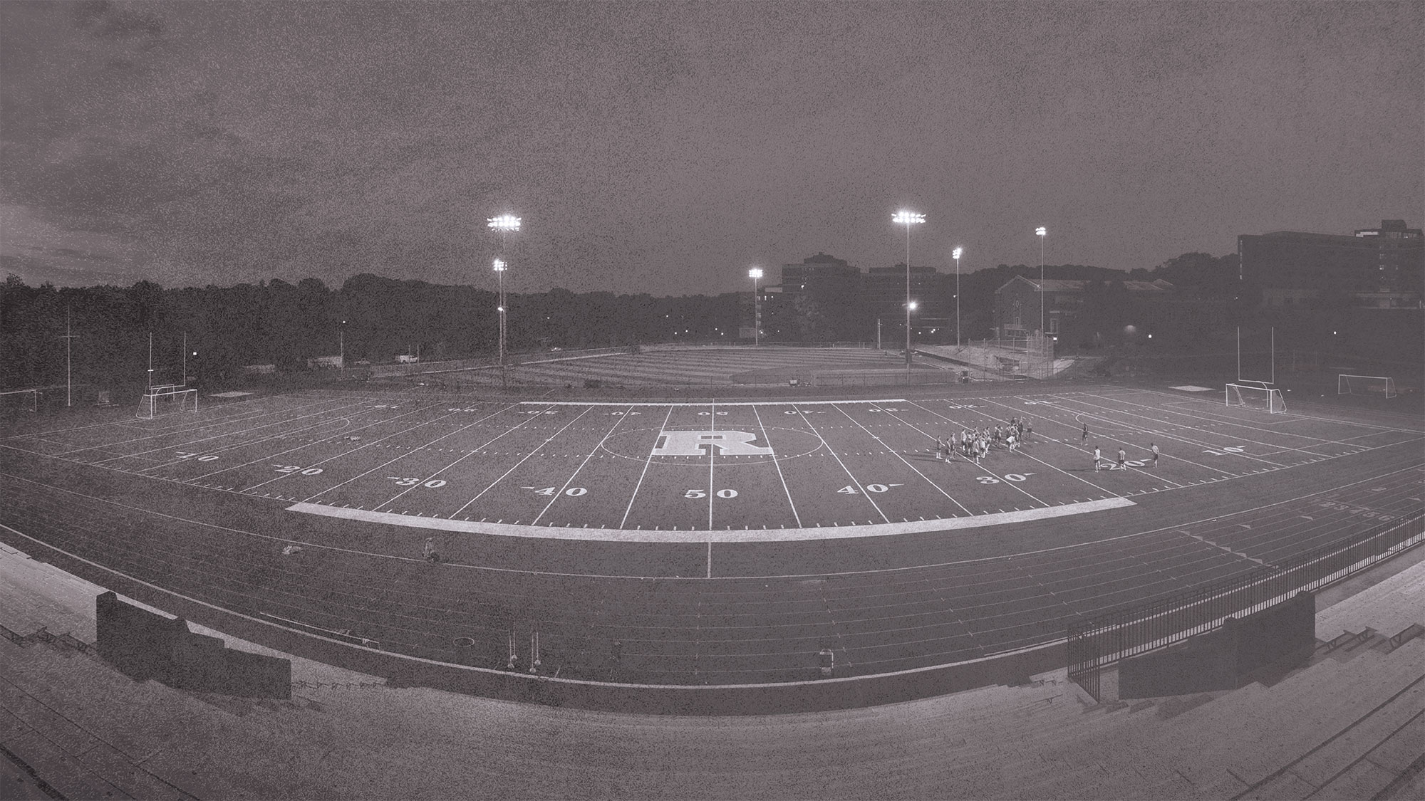 black and white photo of athletic field with the Rochester R at 50 yard line