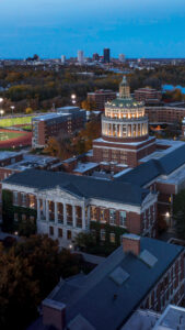mobile cover image of Rush Rhees library aerial view with Rochester skyline in background