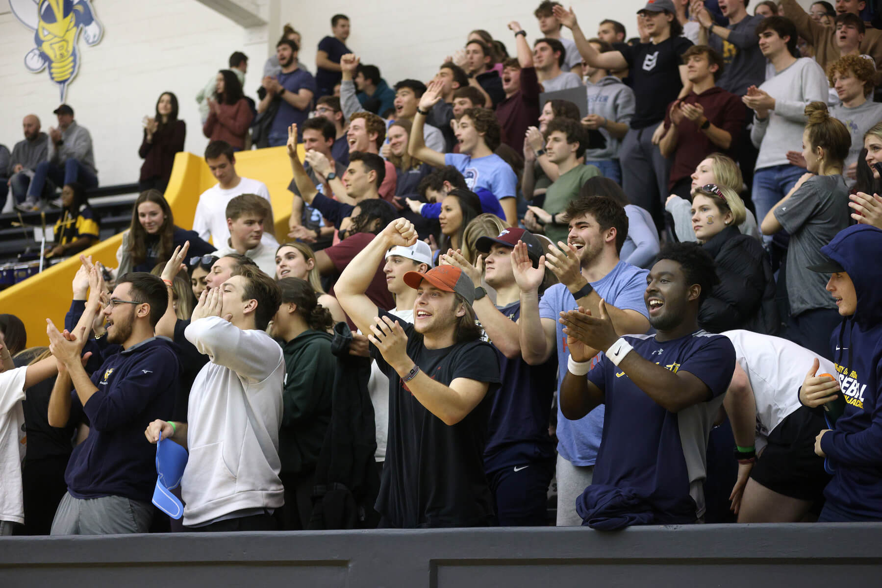 Students and crowd cheering in the stands of the indoor arena at Rochester