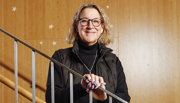 Carol Duquette ’85, ’03S (MBA), standing on staircase
