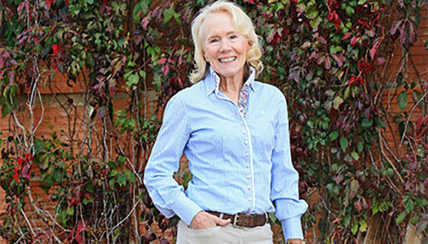 Anne Moore ’70, ’74M (MD) wearing blue button shirt and light pants