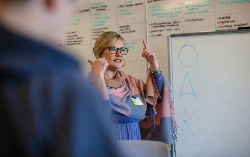 psychnp-classroom Heather Paessler-Chesterton teaches next to a whiteboard in a psychiatric NP class.
