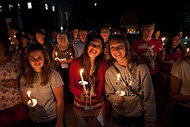 students holding candles at night
