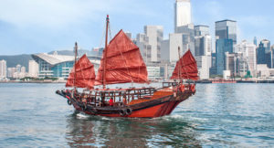 scenic photo of a ship sailing within hong kong