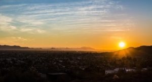 A scenic photo of the sun setting within Phoenix, Arizona.