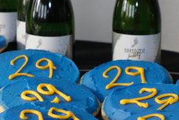 bottles in background and blue cookies with yellow 29 on them in foreground
