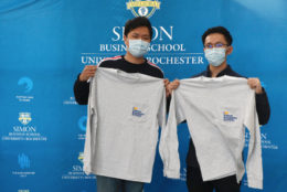 two men posing at photo both holding their i heart simon shirts