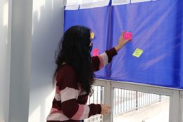 woman placing a sticky note on board