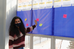 woman placing a sticky note on board