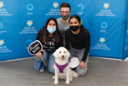 group posing in photo booth and a dog