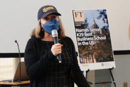 woman in cap wearing mask speaking with microphone