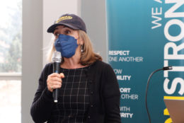 woman in cap, mask and mic in hand