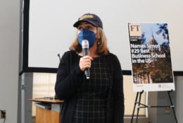 woman in cap wearing mask speaking with microphone