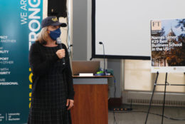 woman in cap, mask and mic in hand