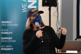 woman in cap, mask and mic in hand