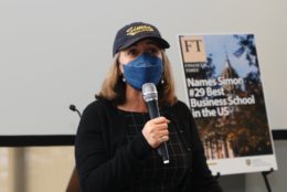 woman in cap, mask and mic in hand