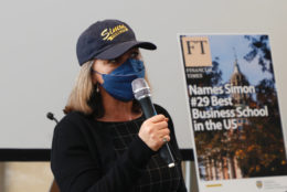 woman in cap, mask and mic in hand