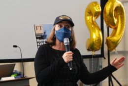 woman in cap and mask holding a mic