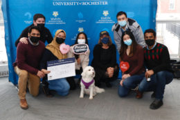group posing in photo booth and a dog
