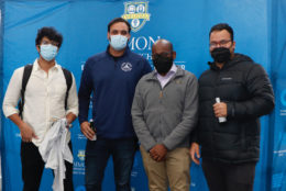 four men posing in photo booth wearing masks
