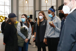 group of people mingling at an event wearing masks