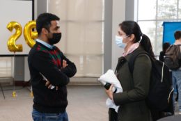 man and woman speaking to each other both wearing masks