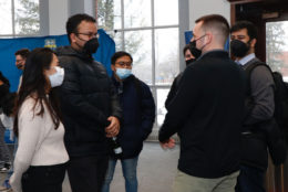 crowd of people mingling all wearing masks