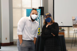 man and woman posing for photo wearing masks