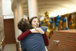 woman giving someone a hug in flaum atrium