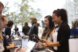 two women smiling checking in at the kiosks