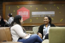 two women seated and talking to each other in lounge area