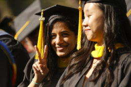 graduate giving peace sign towards camera