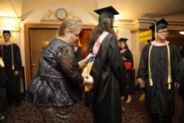 Tami Spencer helps students get ready before they walk for graduation