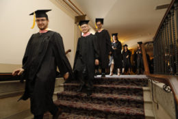 Students get ready for graduation and start to walk to their seats
