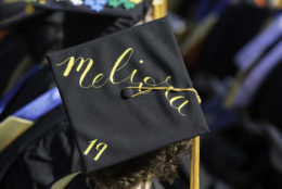 top of graduation cap says 'meliora 19'