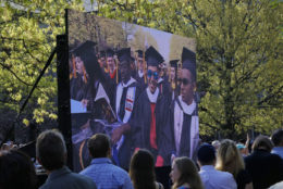 large screen showing smiling graduates