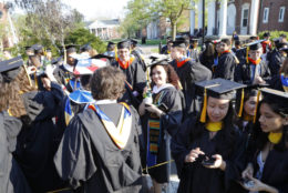 Students chat and get ready in line to walk to graduate