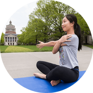 girl practicing yoga on the quad in front of rush rhees library